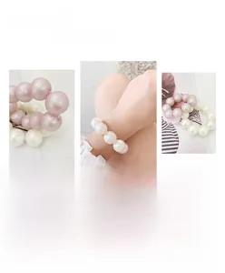 Detail showing the pearlescent texture of pink and white beaded elastic hair ties