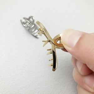 Macro de mini pinces à cheveux dorées et argentées montrant la texture en alliage poli
