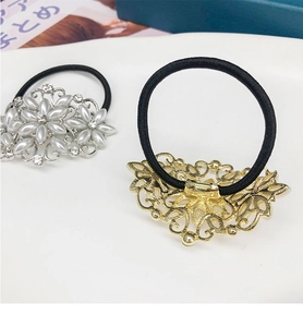 Vue détaillée d'élastiques à cheveux avec perles et strass sur socle en métal décoré