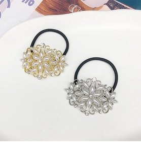 Détail d'élastiques à cheveux fleurs avec perles et cristaux sur un plateau en céramique