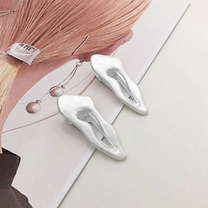Detail of silver irregular hair clips with fluid liquid metal texture and matte finish