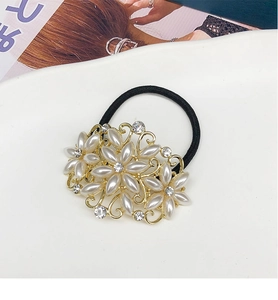 Détail de l'élastique à cheveux en forme de fleur avec perles et cristaux sur plateau