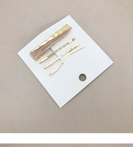 Detailed set of 4 pink acetate and golden metal hair clips on white display card