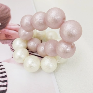 Close-up of matte textured pearl hair ties in pink and cream white colors