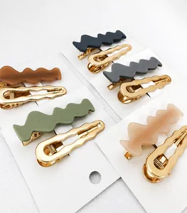 Detail of colorful matte wave hair clips and golden metal clasps on a white display card