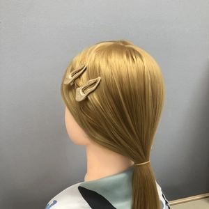 Irregular textured gold metal hair clips for women shown on a model head stand
