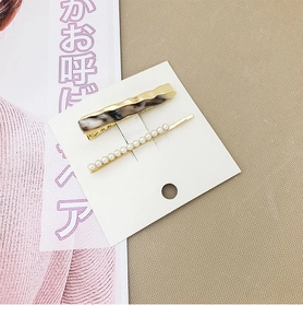 Détail de la pince à cheveux écaillée et barrette à perles délicates sur carte