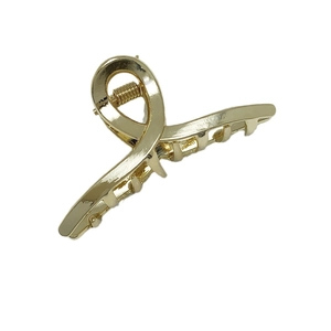 Mini pince à cheveux élégante en alliage plaqué or avec design croisé minimaliste sur fond blanc