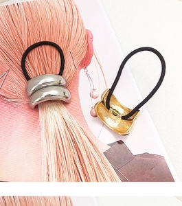 Close-up of sleek curved metal hair ties in silver and gold finishes for ponytails