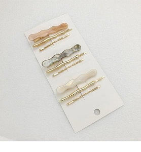Detailed set of nine minimalist hair clips in gold metal and marble acetate textures