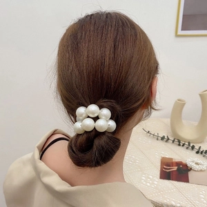 Elegant elastic faux pearl hair tie shown on a low bun hair style with a soft aesthetic