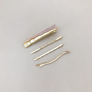 4-piece minimalist hair clip set featuring gold finish and dusty pink acrylic wave design