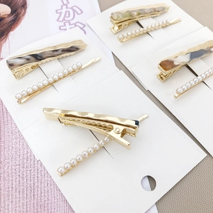 Lot de barrettes dorées élégantes avec texture marbre et perles sur support en carton