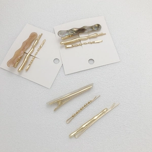 Minimalist marble acrylic and gold metal hair clip set on a white textured background