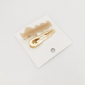 Chic 2-piece hair clip set with beige acrylic wave design and golden metal finish