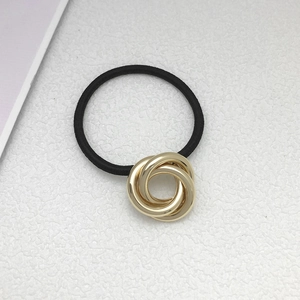 Detail view of golden triple ring metal buckle on a black high-elasticity hair tie band