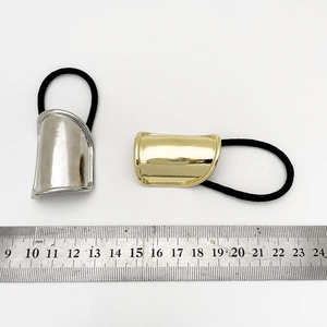 Macro shot of gold and silver metal ponytail holders with ruler for size measurement