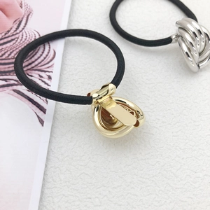 Minimalist twisted metal knot hair ties in polished gold and silver finishes