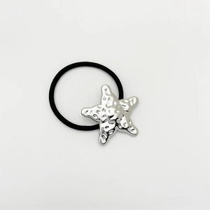 Detail of high-elastic black hair tie with textured silver starfish metal charm