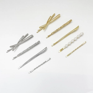 Close-up of alloy hair clips set with faux pearls and textured metallic finish