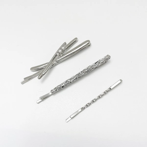 Detailed view of silver alloy hair clips set with pearls and textured relief patterns