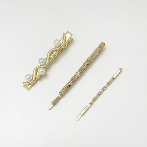 Detailansicht eines 3er-Sets goldener Haarklammern mit Perlen und Hammerschlag