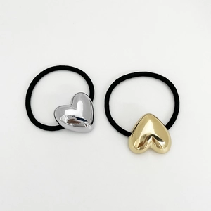 Detailed view of heart-shaped gold and silver metal charms on high-elasticity hair bands