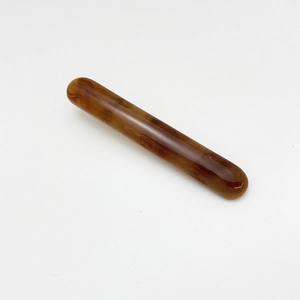 Macro shot of resin hair clip with classic tortoiseshell pattern and amber texture