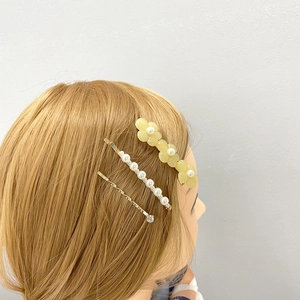 Dreiteiliges Set mit gelben Blumen, Perlenhaarnadel und goldener Clip auf dem Modellkopf