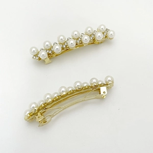 Vue détaillée des barrettes dorées avec perles blanches et petits cristaux brillants