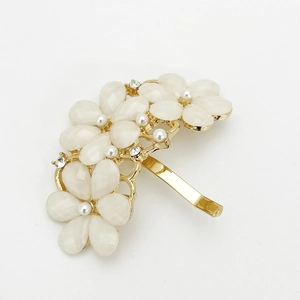 Dettaglio del gancio per capelli a fiore con petali di gemma, piccole perle e strass lucidi