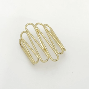 Macro shot of irregular U-shaped hair hook with gold wavy hammer texture finish