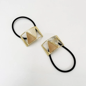 Detail view of U-shaped hair ties with gold frames and marble resin inserts