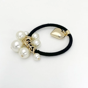 Élastique à cheveux élégant avec perles blanches et pendentif cœur doré sur fond blanc