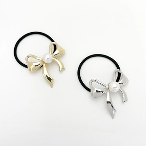 Close-up of elegant pearl bow hair ties with gold and silver metallic finish for ponytails