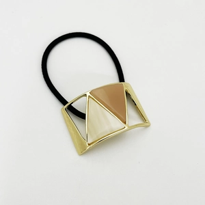 Detail of U-shaped metal hair tie with resin inlays in cream and coffee tones