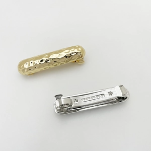 Detail view of gold hammered texture hair clip with spring mechanism and silver back