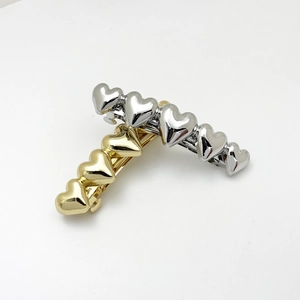 Detail showing polished heart-shaped metal hair clips in gold and silver finishes
