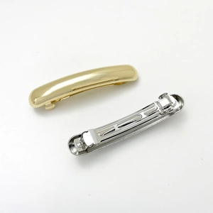 Detailed view of minimalist gold and silver metal spring hair clips with a mirror finish