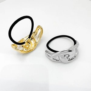 Detail view of gold and silver metal alloy ponytail holders with smooth mirror finish