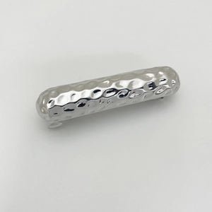 Detail view of the silver metal hair clip featuring a unique hammered texture finish