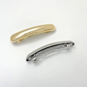 Detail showing high-polish gold and silver alloy spring hair clips in parallel view