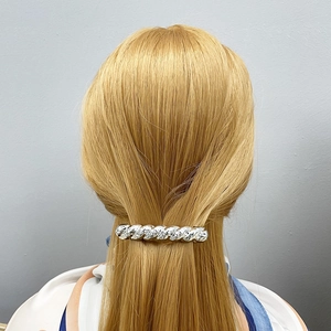 Fermaglio per capelli in metallo argento ritorto con trama martellata su capelli biondi