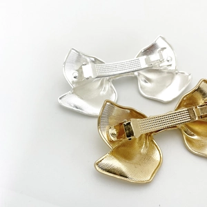 Textured alloy bow hair clips in gold and silver showing the anti-slip spring clamp