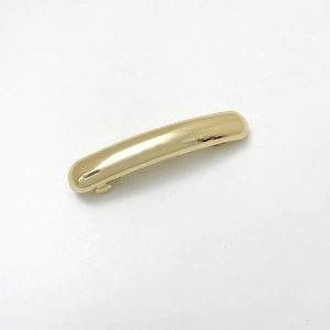 Detailed back view of a minimalist gold metal hair clip with a spring buckle mechanism