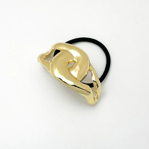 Close-up of golden abstract hollow metal accent on elastic ponytail holder tie