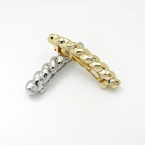 Dettaglio di fermagli per capelli in metallo intrecciato oro e argento con molla