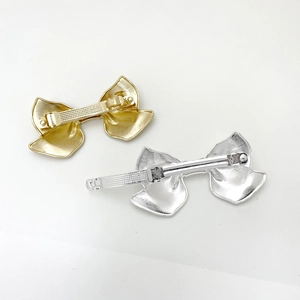 Macro detail of the metal spring clip mechanism on the bow-shaped hair clip set