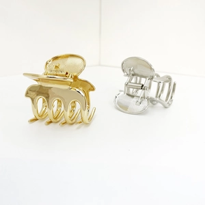 Elegant gold and silver metallic claw clips with geometric diamond pattern on white background