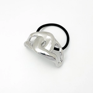 Detail of silver metallic cross ornament on black elastic ponytail holder hair ring